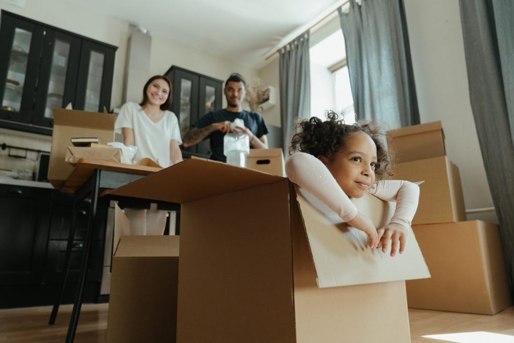  famille heureuse qui emménage au milieu des cartons
